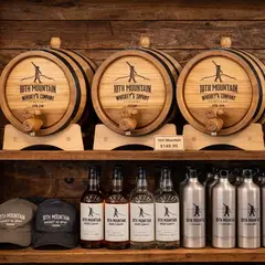 10th Mountain Whiskey custom oak aging barrels displayed on retail shelf with branded bottles and merchandise in distillery gift shop