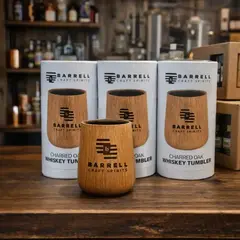 Branded oak whiskey tumblers with custom logo displayed in distillery gift shop as promotional merchandise
