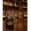 Custom logo 1 oz keychain flask displayed on a bar top with a whiskey bottle in the background, perfect for distillery promotions, tasting rooms, and branded merchandise.