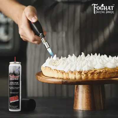 Chef using a kitchen torch fueled by Foghat Culinary Butane to caramelize meringue on dessert for professional culinary presentation