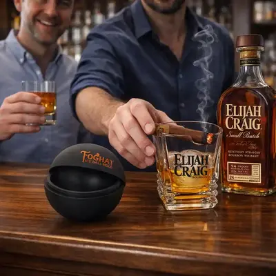 Man enjoying whiskey and cigar with custom branded cigar holder glass at home bar