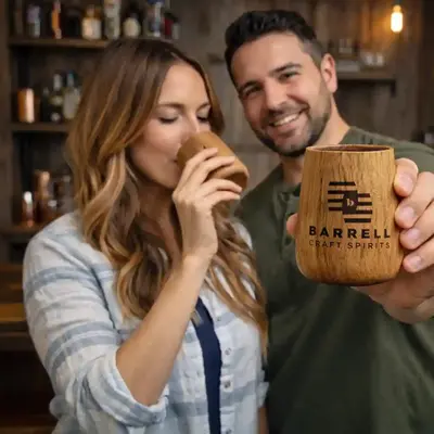 Couple enjoying whiskey from custom engraved oak tumbler promotional product with personalized logo branding